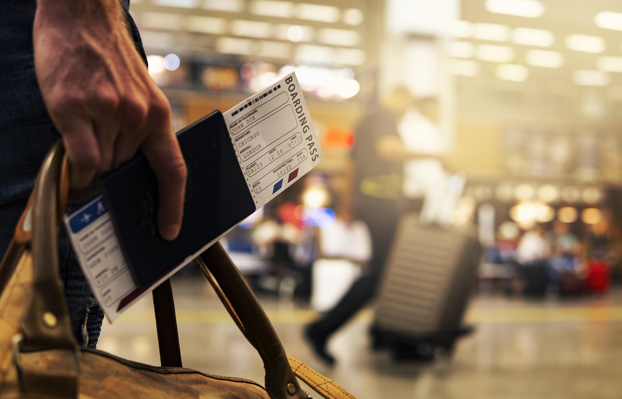 personne dans un aéroport avec son passeport et sa carte d'embarquement