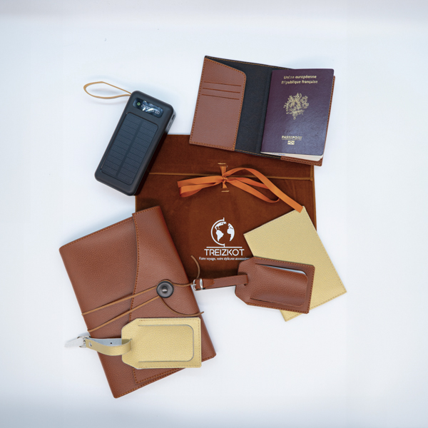 Coffret Duo Treizkot d’accessoires personnalisés pour voyageurs, comprenant protège-passeports, étiquettes bagage, carnet de voyage et batterie externe solaire, dans pochette suédine élégante.