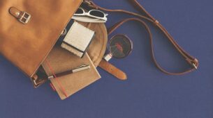 Accessoires de maroquinerie de voyage personnalisée posés pour préparer un départ