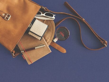 Accessoires de maroquinerie de voyage personnalisée posés pour préparer un départ