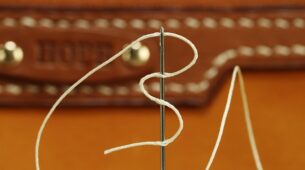 Accessoires de maroquinerie de voyage personnalisée en cuir vegan durable, mis en valeur sur fond naturel avec détail de gravure et finition soignée.